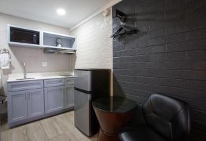 a kitchen with a black brick wall and a chair at The Inn On 66 Flagstaff in Flagstaff