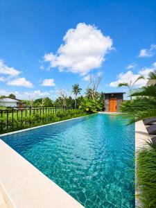 a swimming pool in a villa with blue water at KAPI Sebatu Villa in Tampaksiring