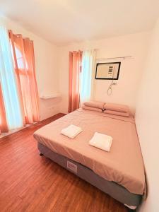a bedroom with a bed with two towels on it at Casa Tranquila Panglao in Dauis