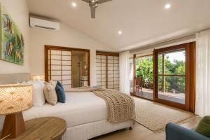 a bedroom with a bed and a couch and a window at Cape Byron Retreat (Adults-Only) in Byron Bay +40 photos