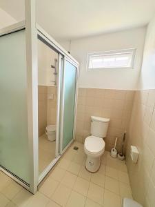 a bathroom with a toilet and a glass shower stall at Casa Tranquila Panglao in Dauis +14 photos