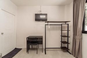 a room with a desk and a television on a wall at Nawin Hotel Donmueang in Thung Si Kan +27 photos