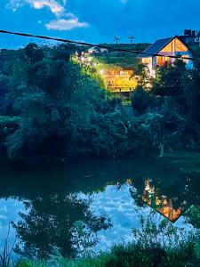 a reflection of a house in the water at night at Moon Mist Villa- Hatton in Hatton