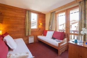 a room with a bed and a couch and windows at Les Résidences de Valmorel - maeva Home in Valmorel