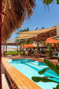 a large swimming pool with tables and umbrellas at Hotel Isla Mujeres Centro & Beach Club Included in Isla Mujeres