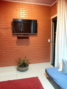 a flat screen tv hanging on a wall at Casa Vilarejo São Jorge in Sao Jorge