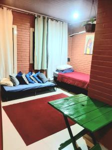 a room with two beds and a table in it at Casa Vilarejo São Jorge in Sao Jorge