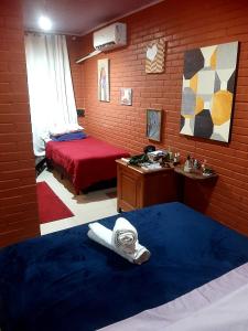 a room with two beds and a desk and a bed sidx sidx sidx at Casa Vilarejo São Jorge in Sao Jorge +6 photos