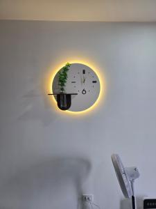 a clock on a wall with a plant on it at Moon bay 384 in Ðoan Xá