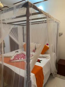 a bedroom with a canopy bed with white curtains at White Bridge House & Resort in Aluthgama