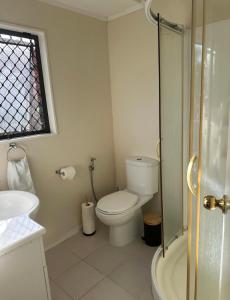 a white bathroom with a toilet and a shower at Peaceful BnB in Rotorua