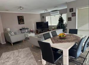 a living room with a table and chairs and a christmas tree at Peaceful BnB in Rotorua