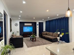 a living room with two couches and a flat screen tv at Cozy and comfortable room - Geelong suburbs in Grovedale +4 photos