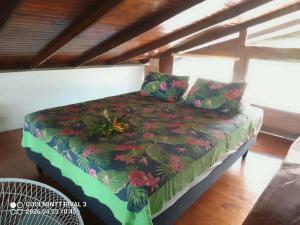 a bed in a room with a flower pattern at Maison charmante bord de mer in Matiti