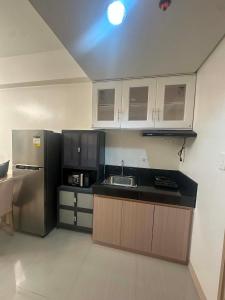 a kitchen with a sink and a refrigerator at Leaf residences 2bedroom Muntinlupa in Manila