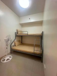 a room with two bunk beds and a fan at Leaf residences 2bedroom Muntinlupa in Manila