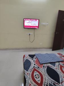 a tv on a wall in a room with a bed at Taj Palace in Covelong
