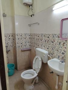 a bathroom with a toilet and a sink at Taj Palace in Covelong