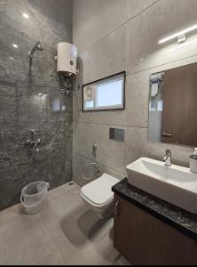 a bathroom with a sink and a toilet and a mirror at Green Villa - Luxury Rooms at peaceful location -200 mtrs away from Bus Stand -500 mtrs from Udaipur Railway Station - Family Suites w Kitchen also available in Udaipur +50 photos