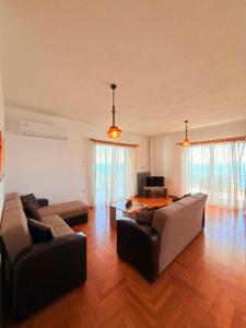 a living room with two couches and a table at Mega Panorama Apartments in Paleo Tsifliki