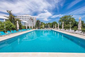 basen z krzesłami i budynkiem w tle w obiekcie Hotel Scoica w mieście Jupiter