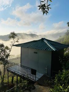a small building with a balcony next to a mountain at Varattumedu Hill in Vagamon