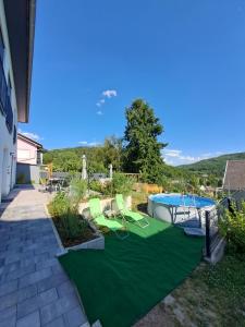 a yard with a green mat and a swimming pool at Ferienwohnung Hahnenblick in Hahnenbach