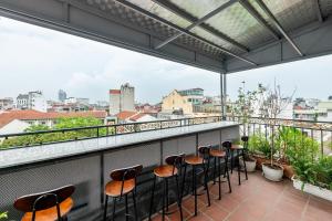 a balcony with stools and a view of the city at Valoria Legend Hanoi Hotel in Hanoi