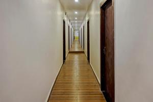 a long hallway with white walls and wooden floors at Collection O Gauri Shree Hotel in Bhopal