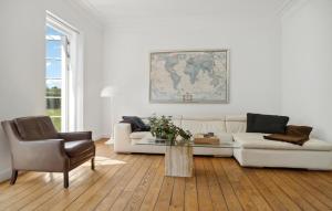 a living room with a white couch and a table at Nice Home In Idestrup With Wifi in Idestrup
