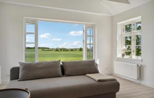 a living room with a couch and a large window at Nice Home In Idestrup With Wifi in Idestrup