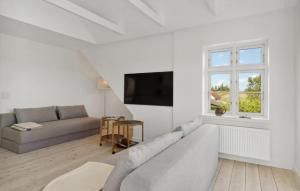 a white living room with a couch and a tv at Nice Home In Idestrup With Wifi in Idestrup +14 photos