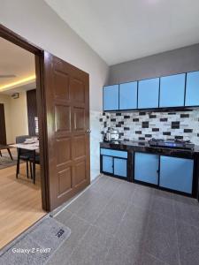 a room with a kitchen with a door and a table at PJ Luxury Homestay in Sipitang