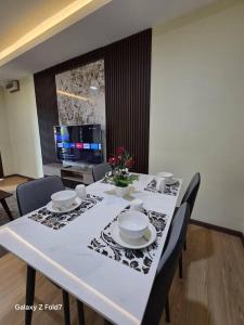 a table with chairs and a white table cloth with a table at PJ Luxury Homestay in Sipitang