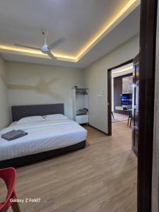 a bedroom with a bed with a ceiling fan at PJ Luxury Homestay in Sipitang