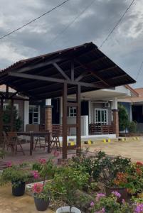 awning over a patio with a table and flowers at PJ Luxury Homestay in Sipitang