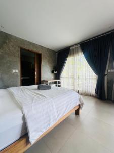 a bedroom with a large bed and a large window at The balangan studio room 7 in Bingin Beach