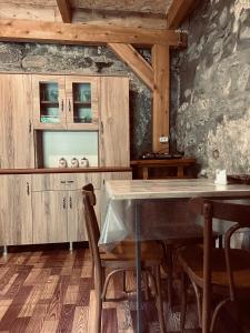 a kitchen with a table and some wooden cabinets at SWEEPH in Mestia