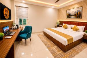 a bedroom with a bed and a desk and a computer at Hotel The Heights in Haridwār