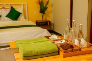 a bedroom with a bed and a table with bottles of wine at Kep Orchid Cafe in Phumĭ Dâmnăk Châng'aeur