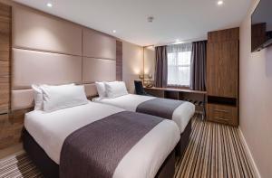 a hotel room with two beds and a desk at Holiday Inn York City Centre by IHG in York +76 photos
