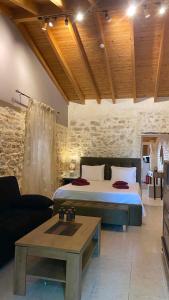 a bedroom with a bed and a couch and a table at CASA THEOTOKI in Anemómylos