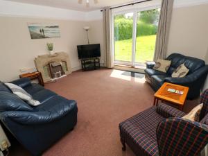 a living room with two couches and a tv at White Thorns in Haverfordwest