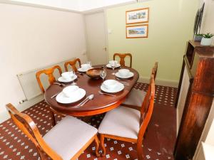 a dining room with a wooden table and chairs at White Thorns in Haverfordwest