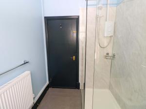 a bathroom with a black door and a walk in shower at White Thorns in Haverfordwest +28 photos