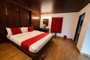 a bedroom with a large bed with red pillows at Misty D Silver in Munnar +23 photos