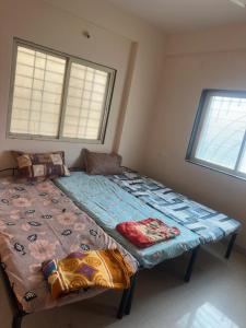 a large bed in a room with two windows at Suyakshi homestay in Pune