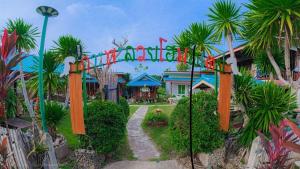 a sign for the entrance to a disney resort at PhaluaiHomestay พะลวยโฮมสเตย์ บ้านไม้ in Koh Phaluai