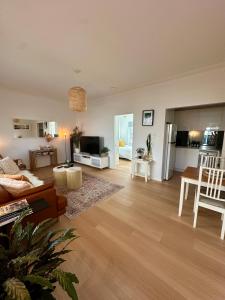 a living room with a couch and a table at Cosy and calm unit in Cronulla in Cronulla