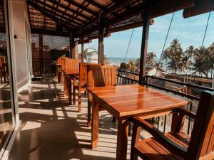 a row of tables and chairs on a balcony with the ocean at Kumarana in Bentota